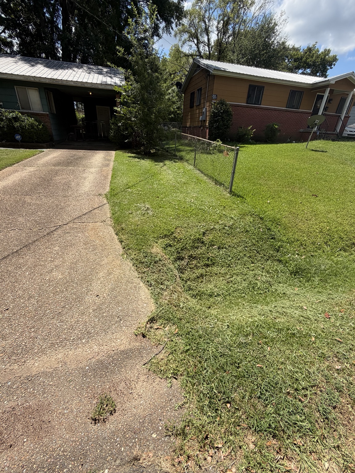Clean driveway edge and cut side lawn after biweekly lawn care in Pearl Mississippi