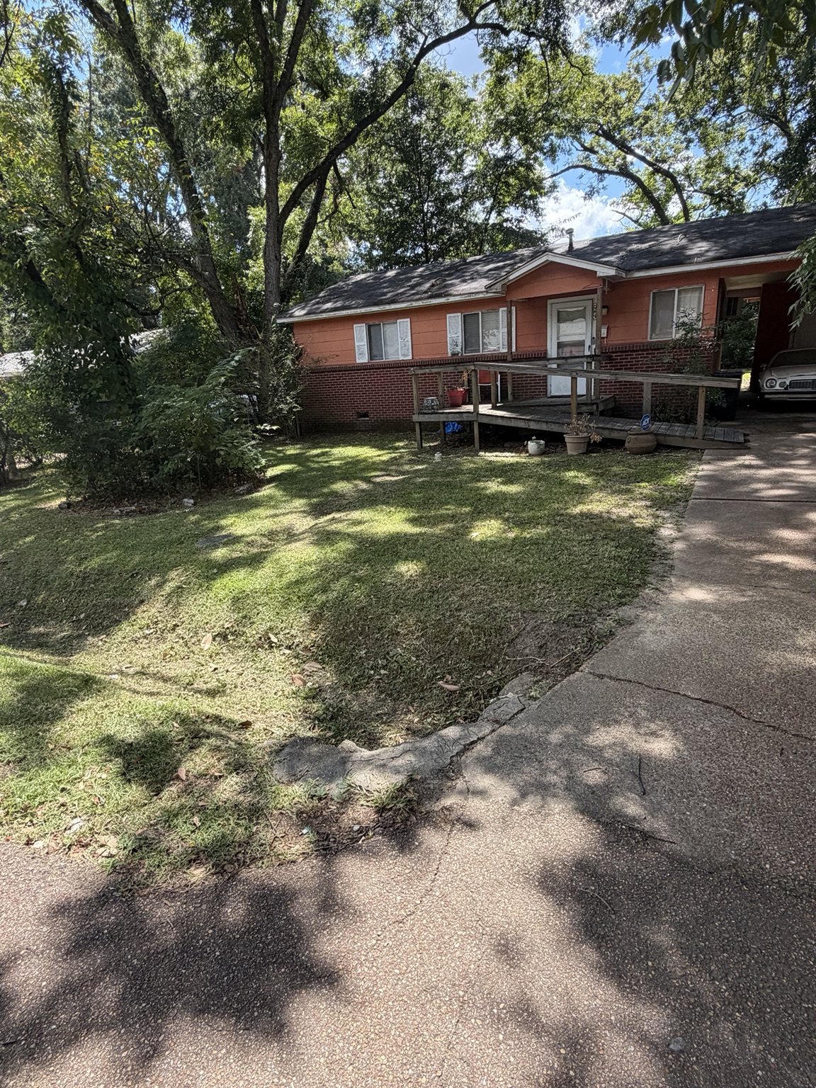 Neatly cut grass and clean driveway border after weekly lawn mowing in Brandon MS