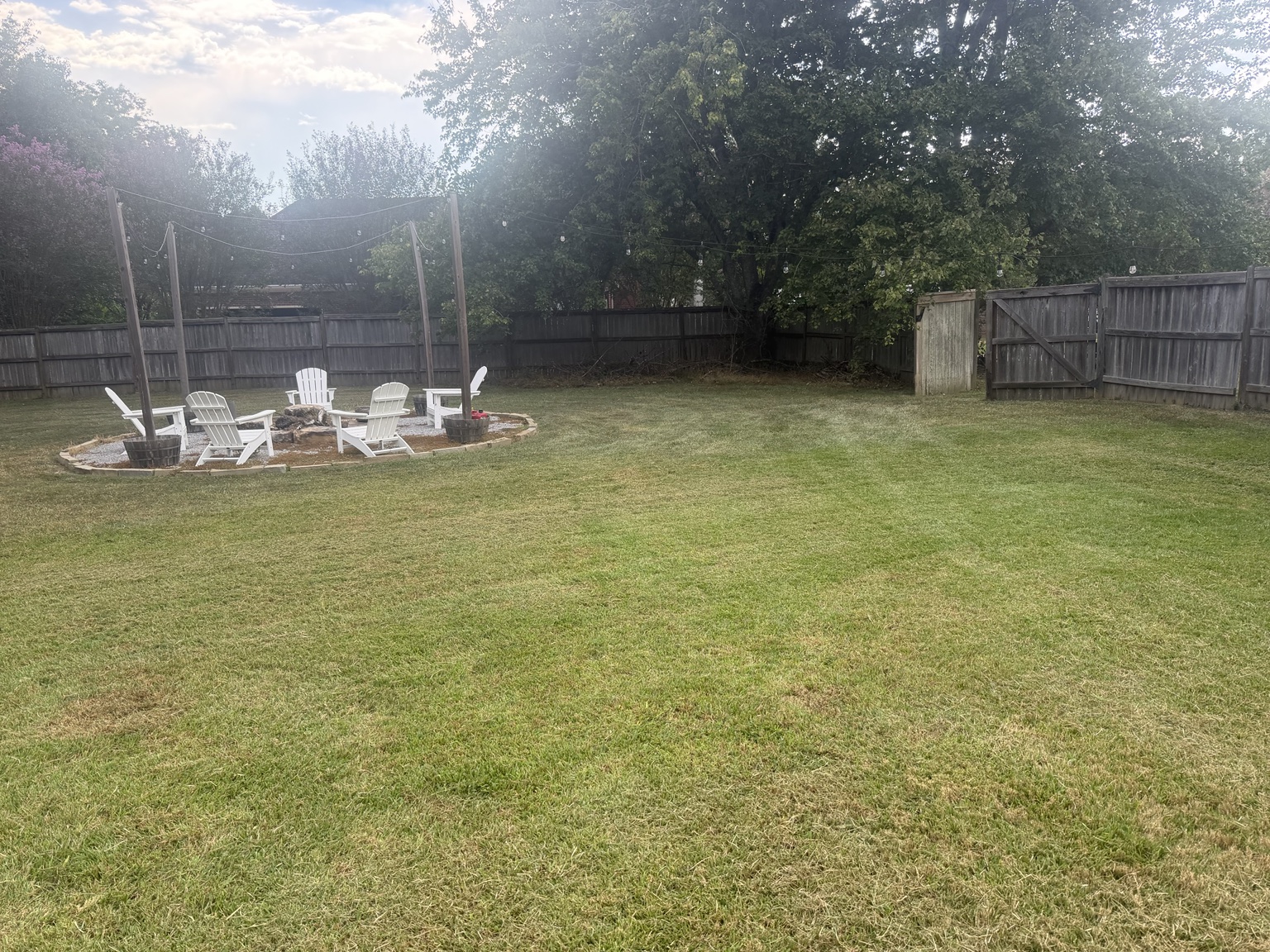Trimmed backyard and fence line after recurring lawn mowing service in Madison MS