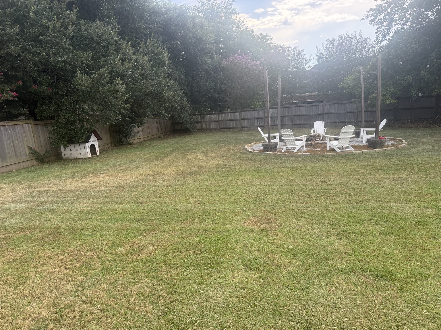 Mowed backyard around a firepit seating area for a Madison Mississippi lawn care customer